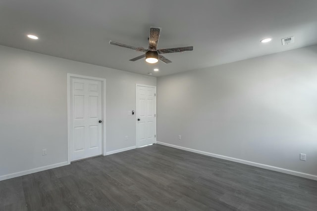 empty room with ceiling fan and dark hardwood / wood-style flooring