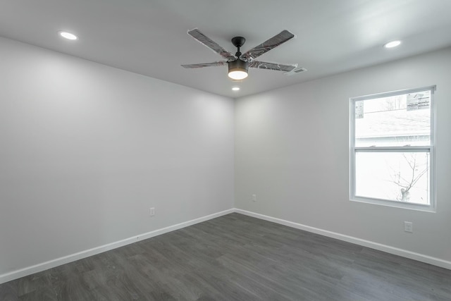 spare room featuring ceiling fan, dark wood-type flooring, and a wealth of natural light