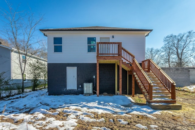 snow covered house featuring central air condition unit