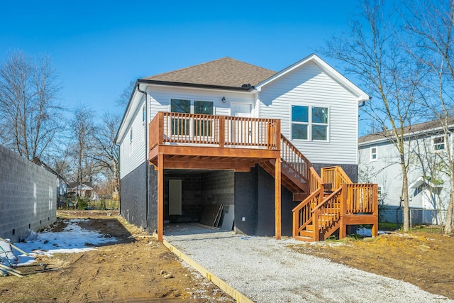 snow covered back of property with a wooden deck