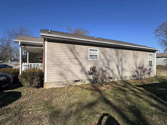 view of home's exterior with covered porch and a lawn