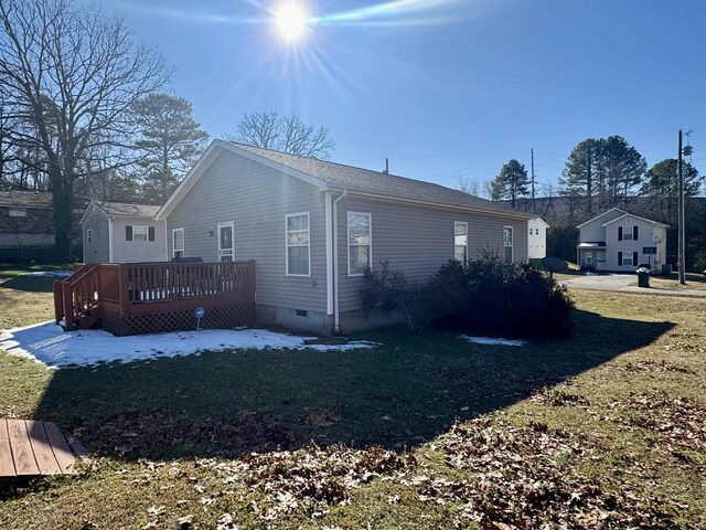 view of side of property with a deck and a yard