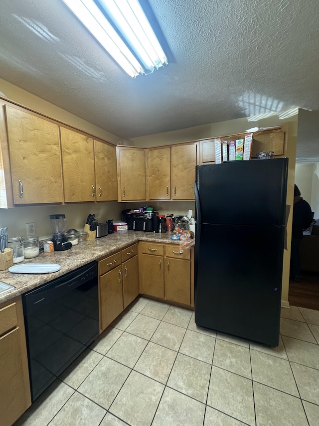 kitchen featuring black appliances, light tile patterned floors, and a textured ceiling