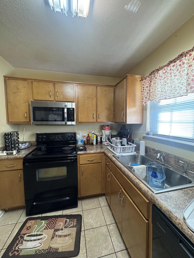 kitchen featuring sink, a textured ceiling, black appliances, and light tile patterned flooring