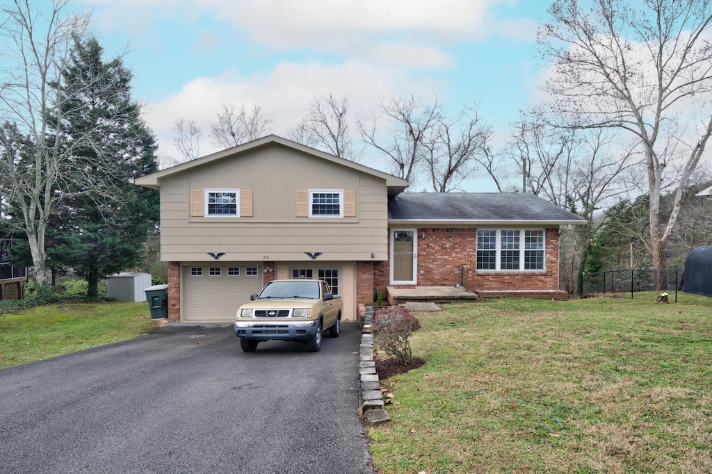 tri-level home with a garage and a front yard