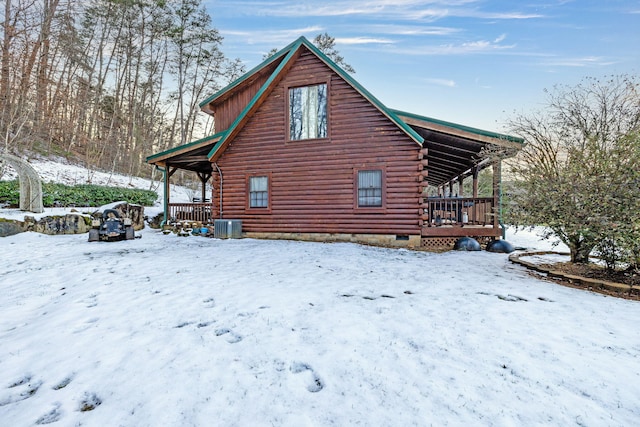 view of snowy exterior with a deck and central air condition unit