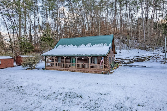 log home with a porch and a shed