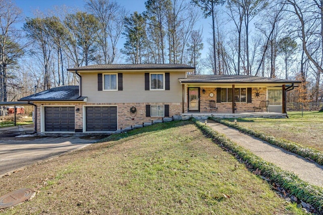 tri-level home featuring a front yard, covered porch, and a garage