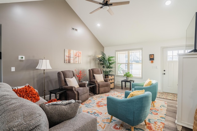 living room featuring ceiling fan, a healthy amount of sunlight, high vaulted ceiling, and light hardwood / wood-style floors