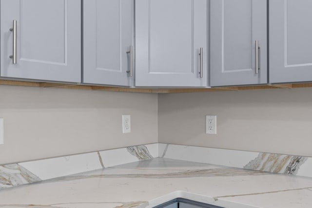 details featuring light stone counters and white cabinets