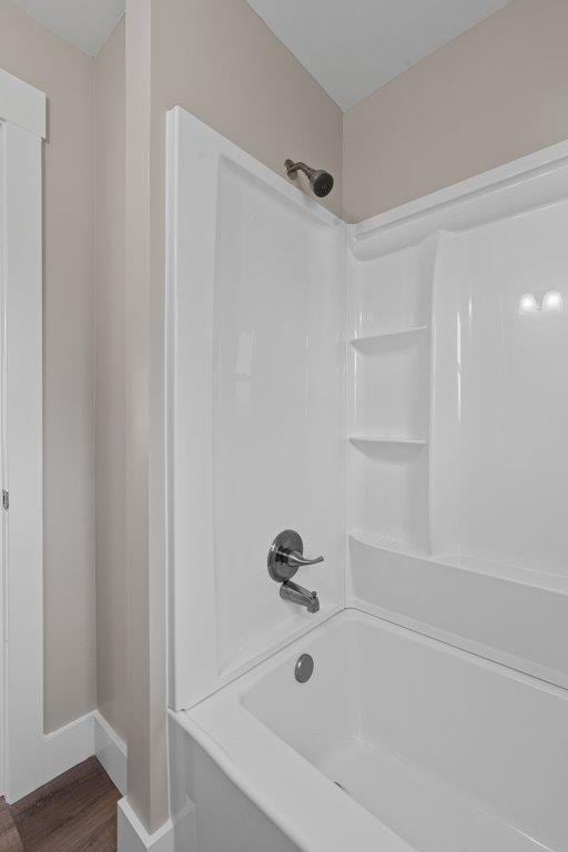 bathroom featuring bathing tub / shower combination and hardwood / wood-style flooring