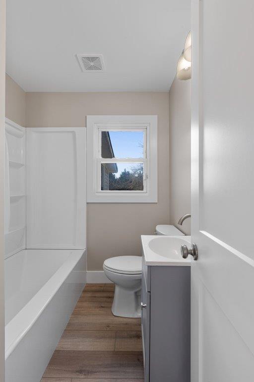 bathroom with toilet, vanity, and hardwood / wood-style flooring