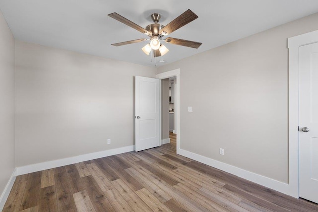 empty room with ceiling fan and light hardwood / wood-style floors