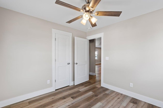 unfurnished bedroom with ceiling fan and hardwood / wood-style flooring