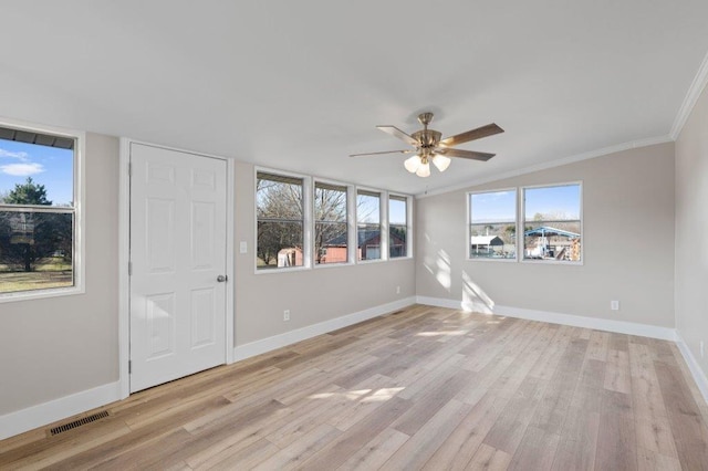 unfurnished room featuring ceiling fan, vaulted ceiling, ornamental molding, and light wood-type flooring