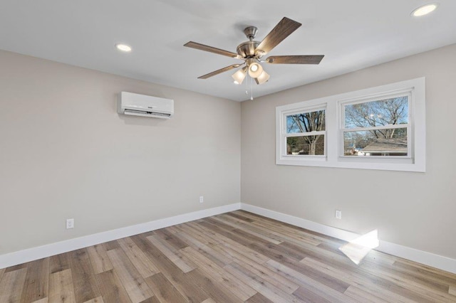 unfurnished room with light wood-type flooring, ceiling fan, and a wall mounted air conditioner