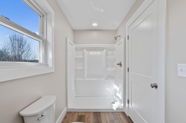 bathroom featuring hardwood / wood-style floors, toilet, and walk in shower