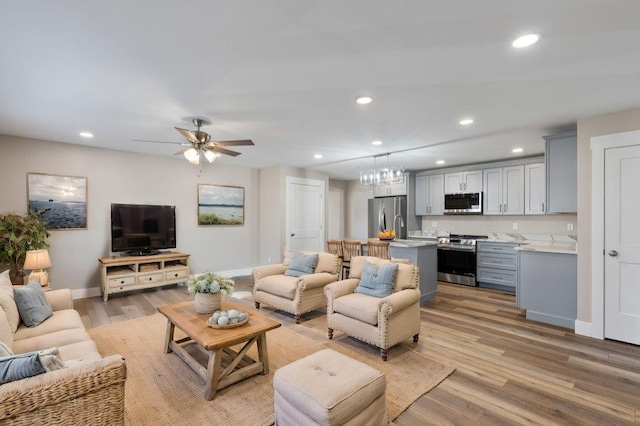 living room featuring ceiling fan and light hardwood / wood-style flooring