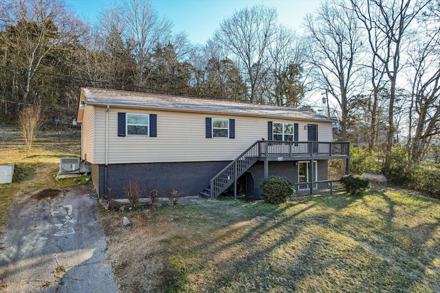 view of front of house with a deck, a front lawn, and central air condition unit