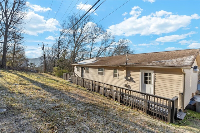 rear view of property featuring a lawn