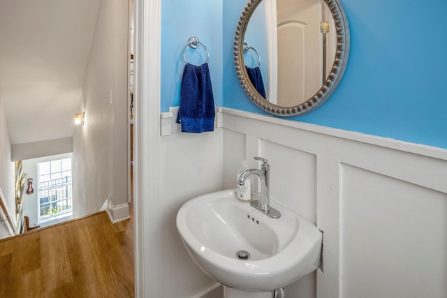 bathroom with vaulted ceiling, hardwood / wood-style flooring, and sink