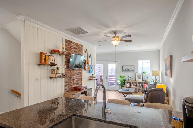 kitchen featuring ceiling fan, crown molding, hardwood / wood-style floors, and sink