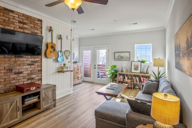 living room with light wood-type flooring, french doors, crown molding, and ceiling fan