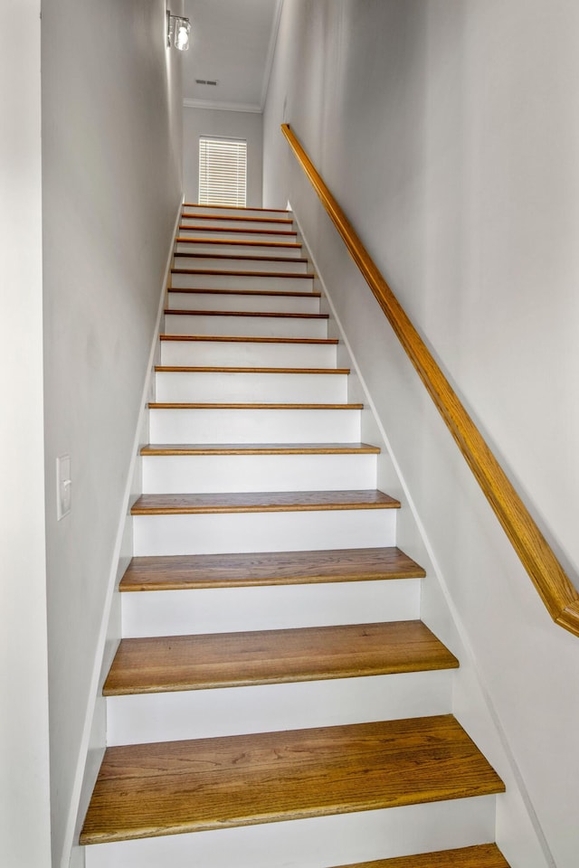 stairs featuring crown molding