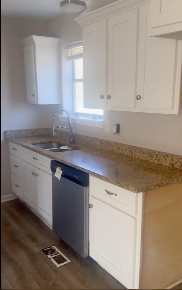 kitchen featuring stainless steel dishwasher, dark hardwood / wood-style floors, sink, and white cabinetry