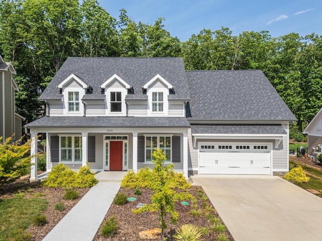 new england style home featuring a porch and a garage