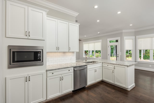 kitchen featuring kitchen peninsula, appliances with stainless steel finishes, dark hardwood / wood-style floors, white cabinets, and sink