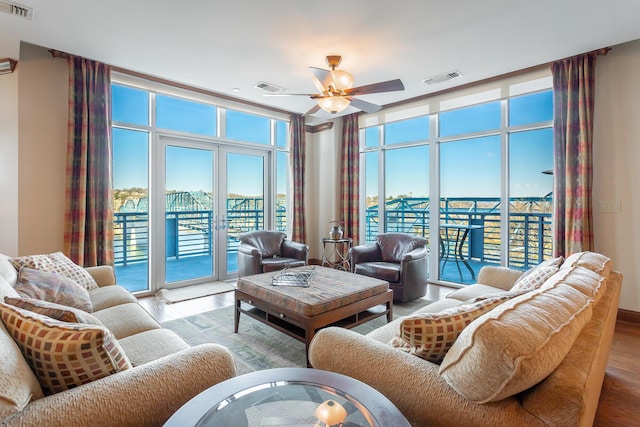 living room with expansive windows, ceiling fan, wood-type flooring, and french doors