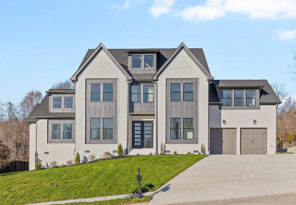 view of front of property featuring a front lawn and a garage