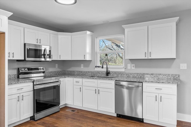 kitchen with appliances with stainless steel finishes, sink, and white cabinetry