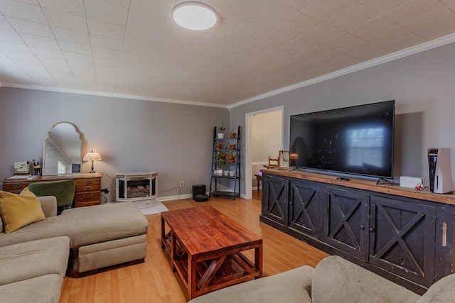 living area with baseboards, light wood-style floors, and crown molding