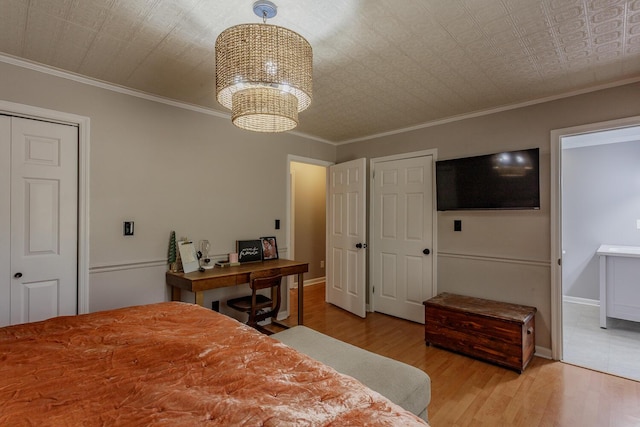 bedroom featuring crown molding, baseboards, wood finished floors, a notable chandelier, and an ornate ceiling