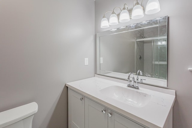 full bathroom with toilet, vanity, and a tile shower