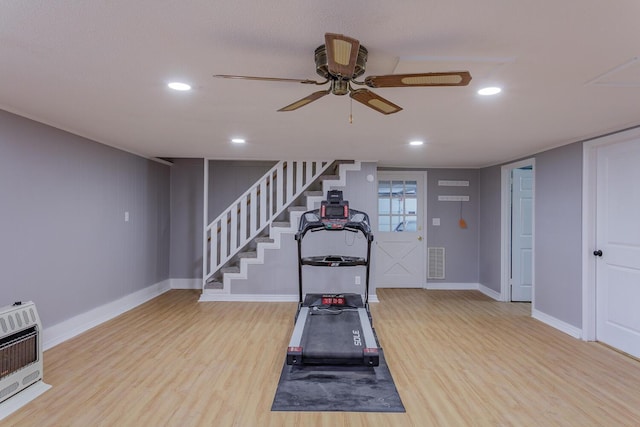 exercise area with heating unit, visible vents, a ceiling fan, and wood finished floors