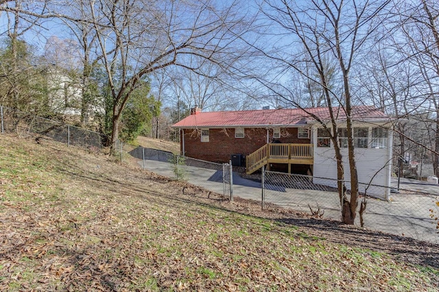 back of property with a fenced front yard, cooling unit, and a chimney