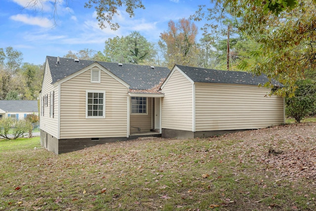 rear view of property featuring a yard