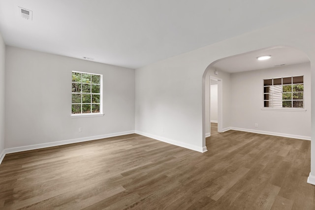 empty room with hardwood / wood-style floors and a wealth of natural light