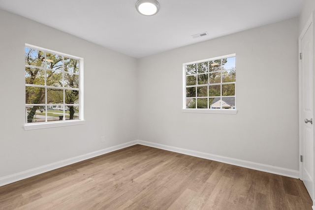 empty room with light hardwood / wood-style flooring and a healthy amount of sunlight