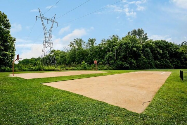 view of property's community featuring a lawn and basketball hoop