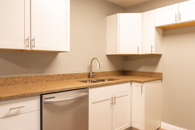 kitchen featuring white cabinets, dishwasher, sink, and light stone counters