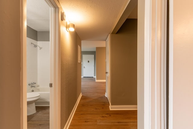 hallway featuring a textured ceiling and hardwood / wood-style floors