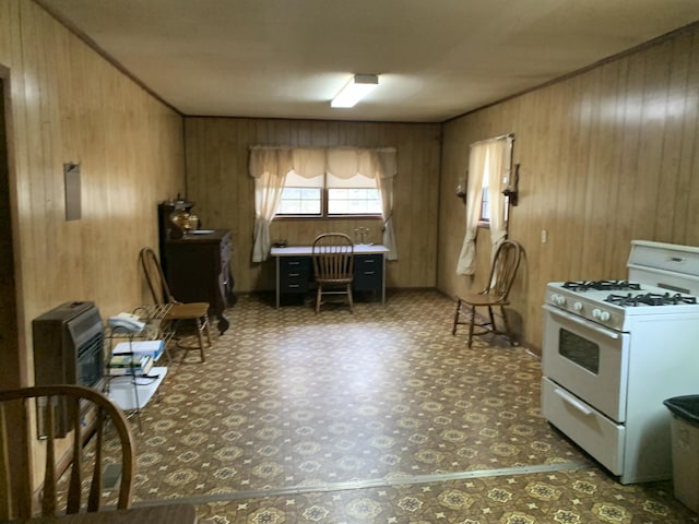 kitchen with white range with gas stovetop and wooden walls