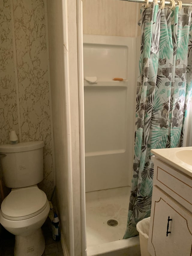 bathroom featuring toilet, vanity, and a shower with curtain