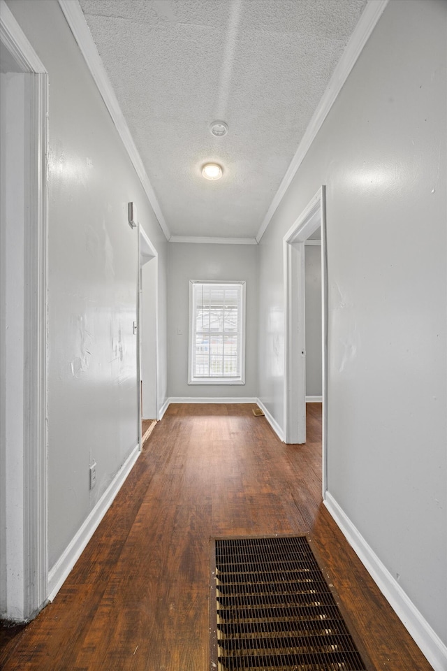 hall featuring a textured ceiling, dark hardwood / wood-style floors, and ornamental molding