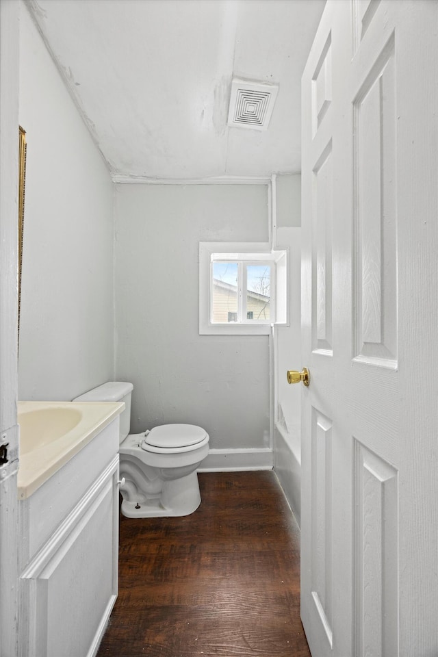 bathroom with hardwood / wood-style flooring, toilet, and vanity