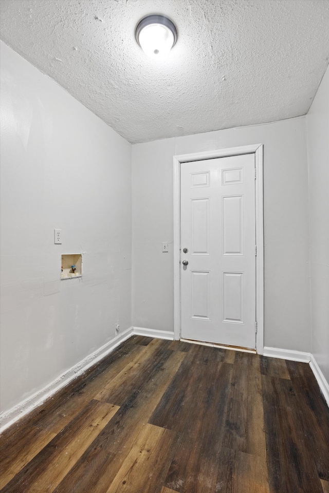 unfurnished room featuring a textured ceiling and dark hardwood / wood-style floors